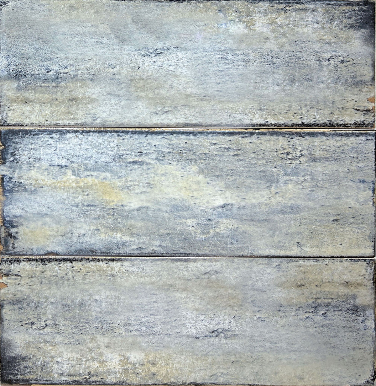Delta Sky Glossy 5x13 ceramic wall tile, close-up of three pieces in a blue-grey glossy glaze