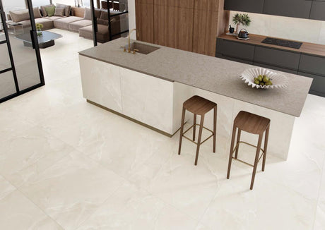 Modern kitchen with a stone-topped island and wood bar stools on Scarlet Soft Ivory 12x24 matte porcelain floor tile
