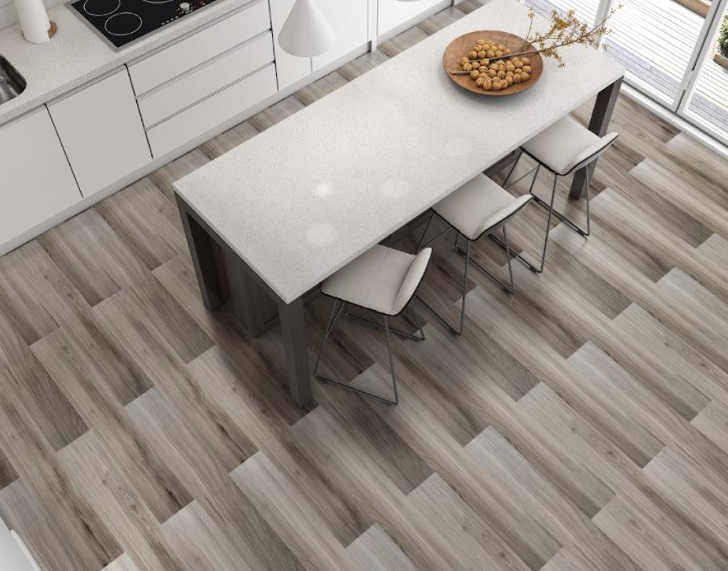 Modern kitchen with wood-look plank flooring around a white island with bar stools and sliding glass door