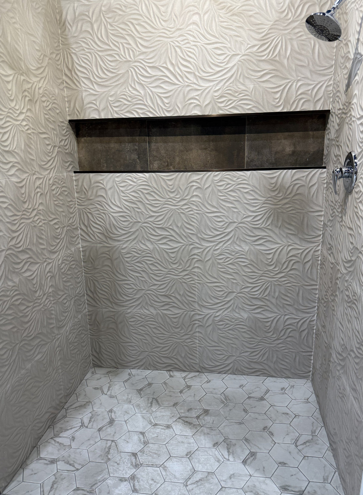 Walk-in shower with hex mosaic floor and textured wall tile — dense floor joints are where epoxy grout often earns its keep