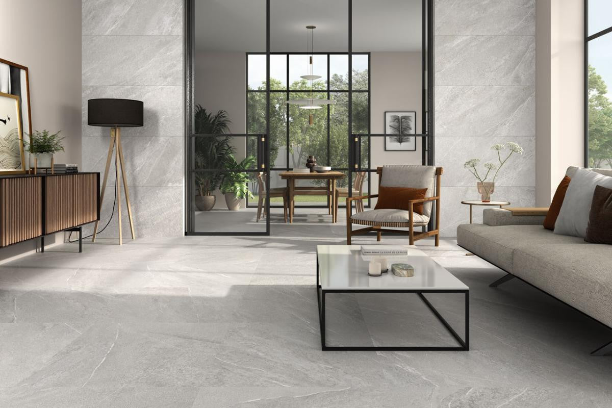 Modern living room with Spanish porcelain gray tiles, a glass coffee table, and a sofa.