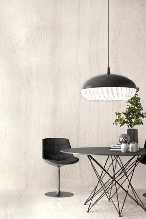 Modern dining area with a black pendant light, table, and chair against a seamless large porcelain panel wall.