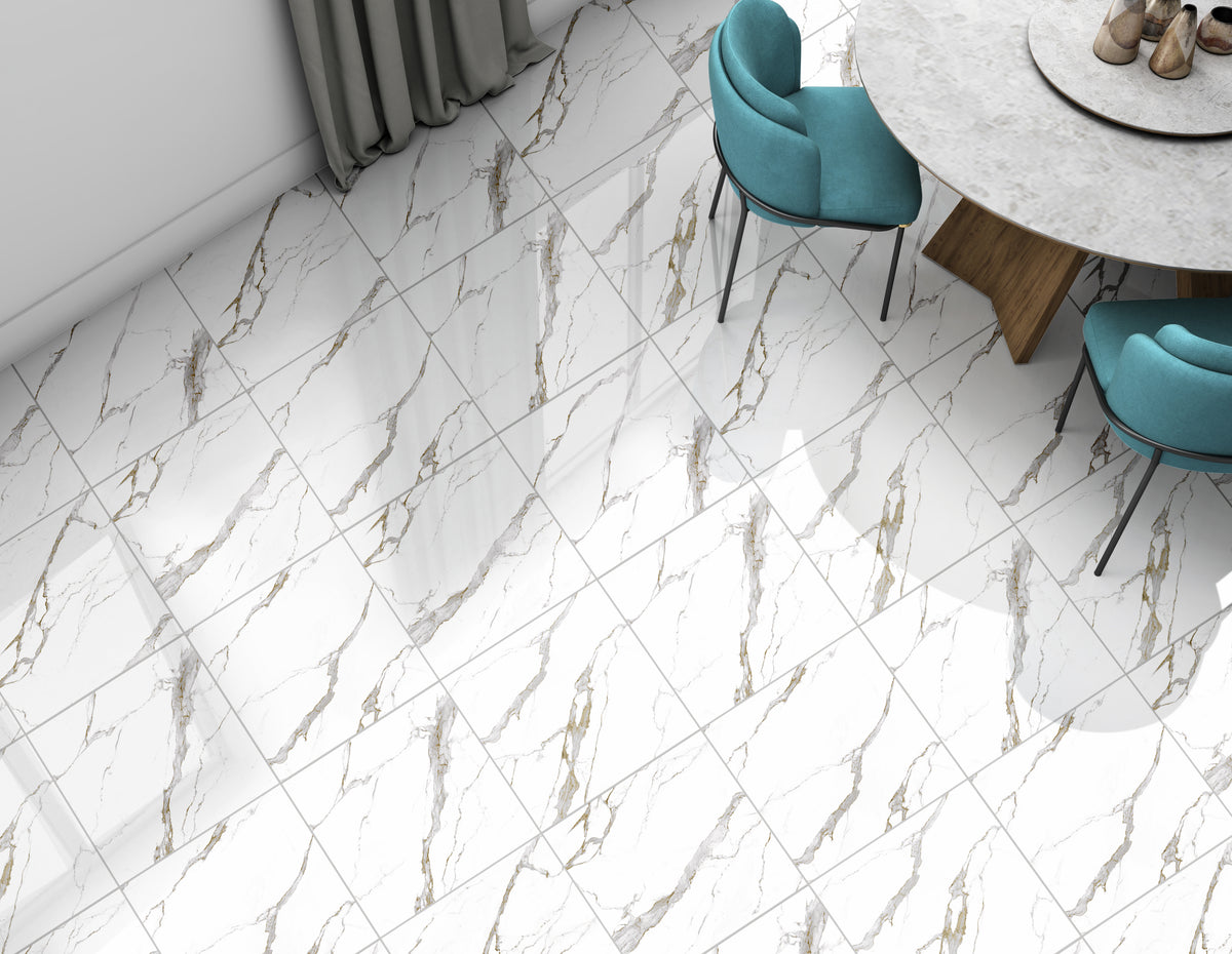 White marble-look floor tiles with elegant gold and gray veining, shown in a modern dining room setting with teal chairs and a round marble table.